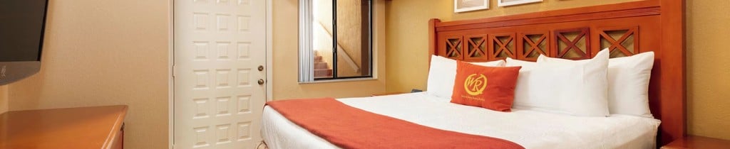 Studio Villa bedroom at Westgate Vacation Villas with a king bed, carved wood headboard and Westgate Resorts cushion